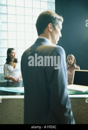 Uomo e due donne in ufficio Foto Stock