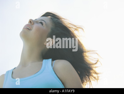 La ragazza con la testa indietro e il vento nei capelli Foto Stock