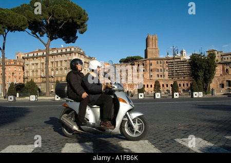 Giovane su scooter in Via dei Fori Imperiali street, Roma Italia Foto Stock