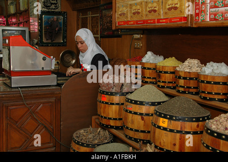 Un egiziano negoziante conteggiare denaro dietro una cassa o un registratore di cassa in Khan el-Khalili un grande souk nel centro storico del Cairo islamico Egitto Foto Stock