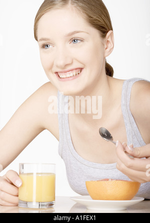 Giovane donna con succo di pompelmo e un bicchiere di succo di pompelmo Foto Stock