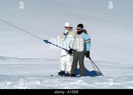 Due giovani sciatori su swiss ski trascina sollevare verbier svizzera alpine ski resort sport Foto Stock