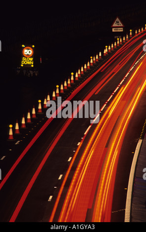 Il traffico pesante che passa a 50 mph velocità di limitazione segnale di avvertimento contraflow sulla a1 autostrada m1 nei pressi di Leeds di notte regno unito Foto Stock