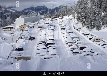Auto coperto di neve pesante nel parco auto Foto Stock