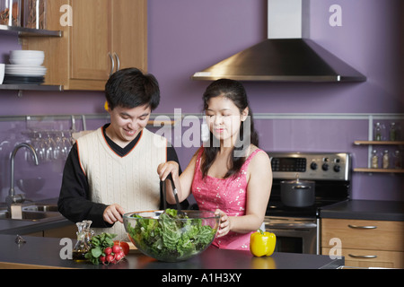 Close-up di un giovane uomo in piedi con una metà donna adulta in cucina Foto Stock