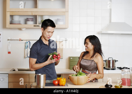 Close-up di un giovane uomo e una giovane donna in piedi e tenendo ortaggi a radice Foto Stock
