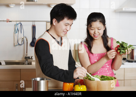 Close-up di un giovane uomo e una metà donna adulta la preparazione di alimenti Foto Stock
