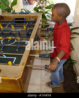 Ragazzo gioca il calcio balilla Bakau Gambia Foto Stock