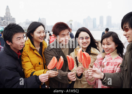 Close-up di tre giovani uomini e tre donne giovani tenendo i cocomeri Foto Stock