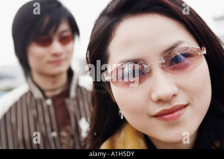 Ritratto di una giovane donna che indossa gli occhiali da sole Foto Stock