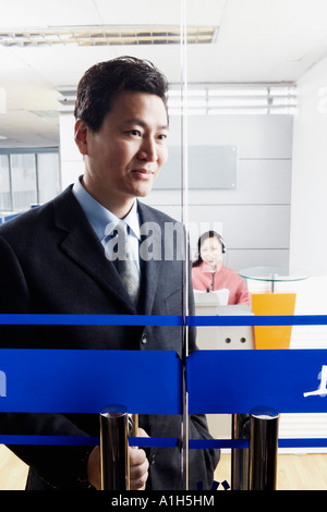 Close-up di un imprenditore in piedi in un ufficio con una donna matura di indossare una cuffia Foto Stock