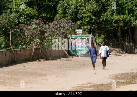 Due studenti a piedi sulla strada polverosa vicino Berending scuola di villaggio a sud del Gambia Foto Stock