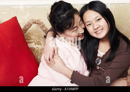 Ritratto di una ragazza che abbraccia la nonna Foto Stock