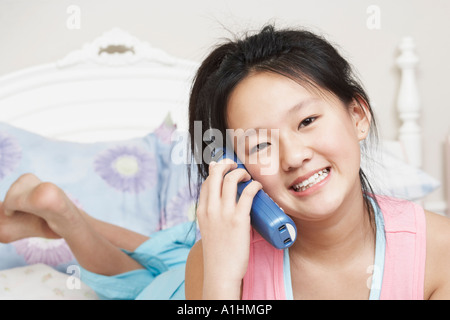 Ritratto di una ragazza utilizzando un telefono cordless Foto Stock