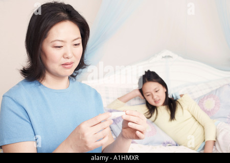 Close-up di una madre controllando la figlia della temperatura Foto Stock