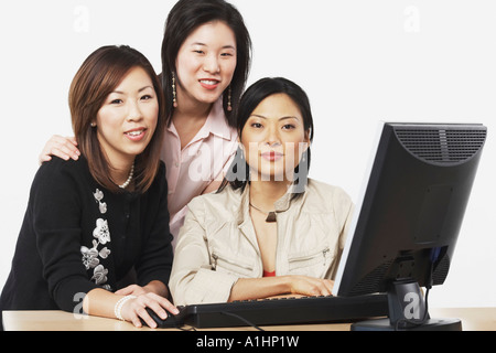 Ritratto di tre imprenditrici a sorridere di fronte a un computer Foto Stock