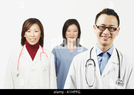 Ritratto di un medico di sesso maschile con un medico di sesso femminile e una femmina di infermiere in piedi dietro di lui Foto Stock