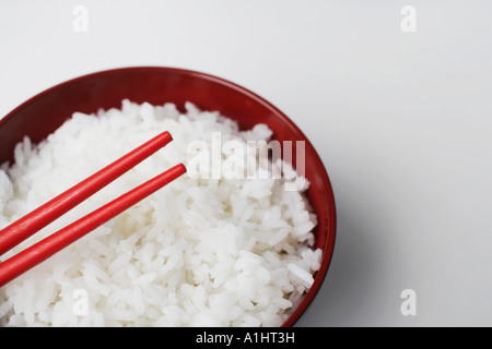 Elevato angolo di visione di un paio di bacchette su una ciotola di riso Foto Stock