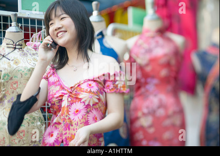 Giovane donna a parlare su un telefono mobile Foto Stock