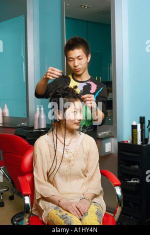 Parrucchiere maschio con ragazza adolescente in un salone Foto Stock