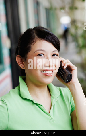 Ritratto di una giovane donna che parla su un telefono cordless Foto Stock