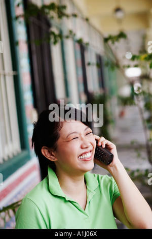 Close-up di una giovane donna che parla su un telefono cordless Foto Stock