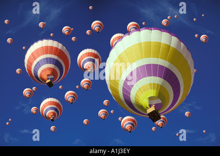 Gialla singola mongolfiera tra centinaia di rosso i palloni ad aria calda Foto Stock