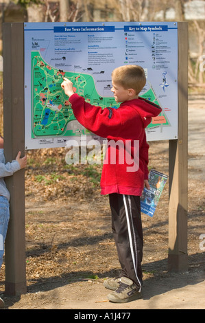 9 bambino di nove anni studente guarda una mappa a Detroit Michigan Zoo Foto Stock