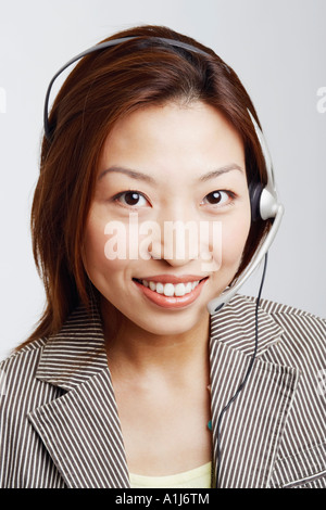 Ritratto di una imprenditrice che indossa gli auricolari e sorridente Foto Stock