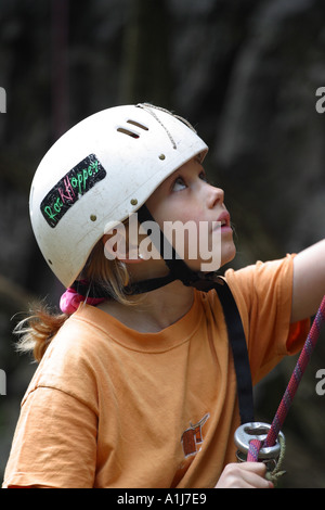 Ragazza giovane arrampicata roccia con il casco e la fune di sicurezza in Mendip Hills Somerset Foto Stock