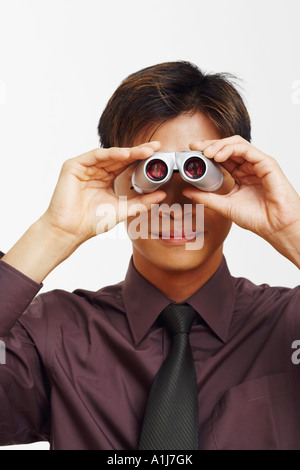 Close-up di un imprenditore cerca attraverso un paio di binocoli Foto Stock