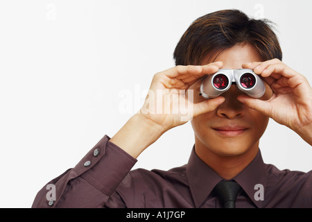 Close-up di un imprenditore cerca attraverso un paio di binocoli Foto Stock