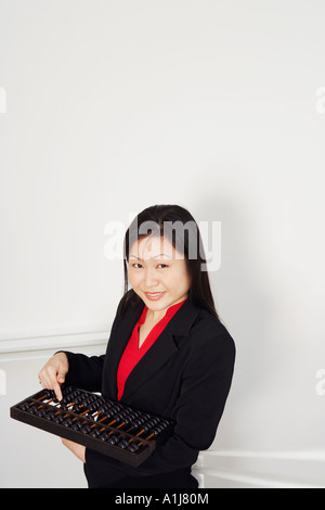 Ritratto di una imprenditrice tenendo un abaco e sorridente Foto Stock