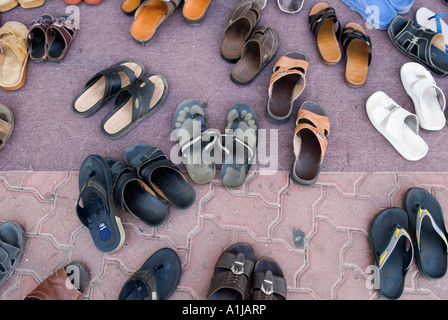 Abu Dhabi Emirati Arabi Uniti UAE tipico slittamento su scarpe e pantofole a sinistra al di fuori di una moschea durante la preghiera Foto Stock