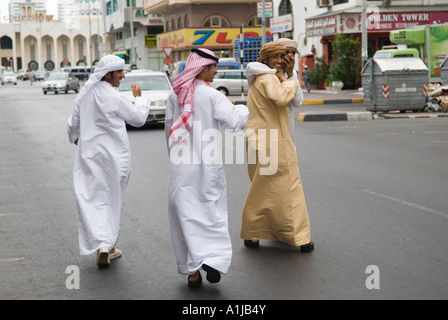 Abu Dhabi giovani uomini arabi che indossano i loro abiti tradizionali abiti arabi maschi - Kandura noto anche come dishdasha o thobe UAE 2006 2000s HOMER SYKES Foto Stock