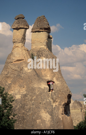 La Turchia Cappadocia Zelve donna in fairy camino intagliato la formazione di roccia Foto Stock