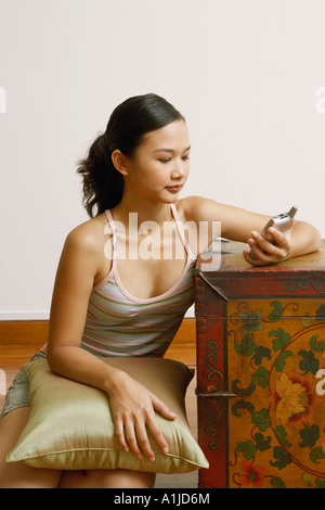 Giovane donna in possesso di un telefono cellulare Foto Stock