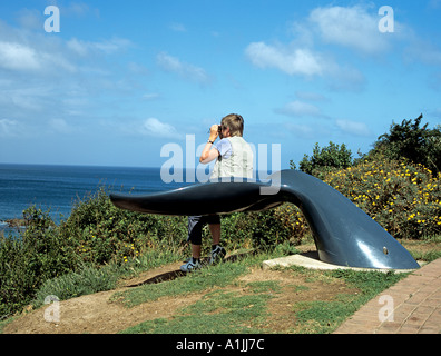 PLETTENBERG BAY IN SUD AFRICA Ottobre donna seduta su una coda di balena posto al whale watching lookout in alto al di sopra della baia Foto Stock