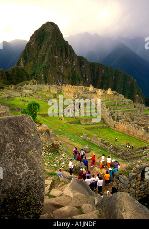 Persone i turisti in visita a Machu Picchu aka la Città perduta degli Incas un Inca rovina dall'impero Inca nelle montagne delle Ande del Perù Sud America Foto Stock