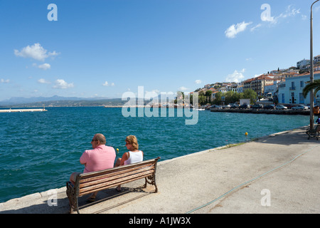Giovane seduto sul lungomare del porto di Pylos, vicino Yialova, Messinia, Peloponneso, Grecia Foto Stock