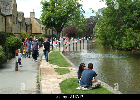 I turisti a piedi sulla strada alzaia a Bourton sull'acqua Gloucestershire England Regno Unito Regno Unito Foto Stock