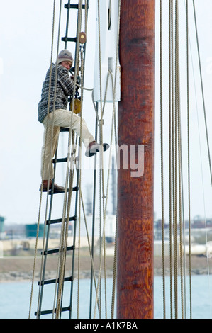 Lavoratori di sesso maschile e di sesso femminile fare maintence e riparazioni sul tall ship Highlander ancorato nel St Clair River Port Huron Michigan Foto Stock