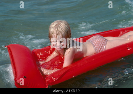 Bambina su un lilo; Northumberland, England, Regno Unito Foto Stock