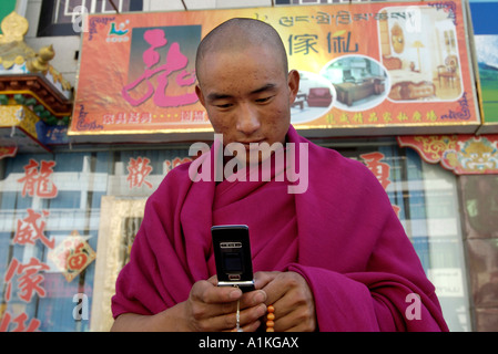 Un monaco tibetano controlla il suo telefono cellulare in una strada dello shopping a Lhasa il Tibet Ottobre 19 2006 Foto Stock