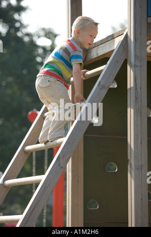 Little Boy salendo su una scala Foto Stock