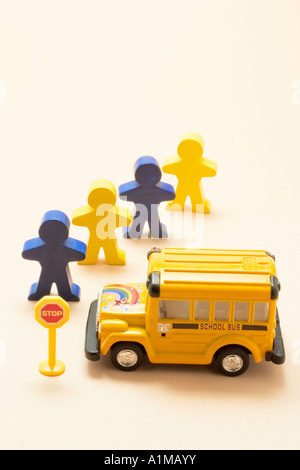 Bambini in legno figure e il bus di scuola Foto Stock