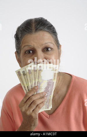 Indian senior citizen con carta moneta rupie in mano Foto Stock