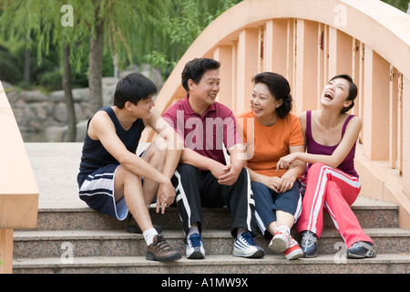 Famiglia seduti insieme sul ponte a piedi Foto Stock