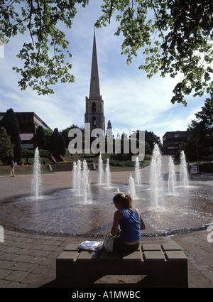 Worcester fontane impostato in area pavimentata con la guglia resti di St Andrews chiesa al di là e giovane signora seduta sul banco di lavoro Foto Stock