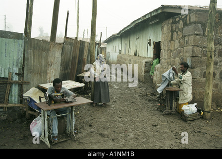 Gli uomini con le macchine da cucire per la riparazione e rendere abbigliamento al di fuori della strada in un Bati Foto Stock